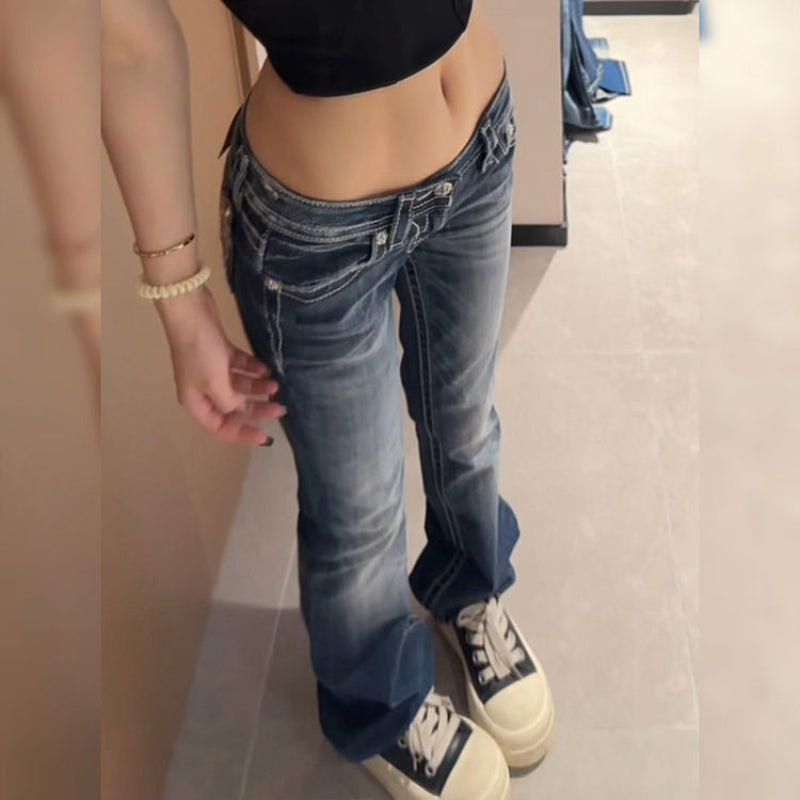 Person wearing blue jeans and a black top in an indoor setting