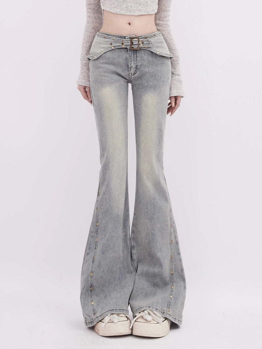 Person wearing light blue flared jeans on a white background