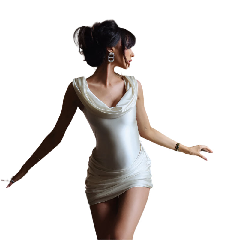 Woman in a white dress standing in a room with decorative elements.