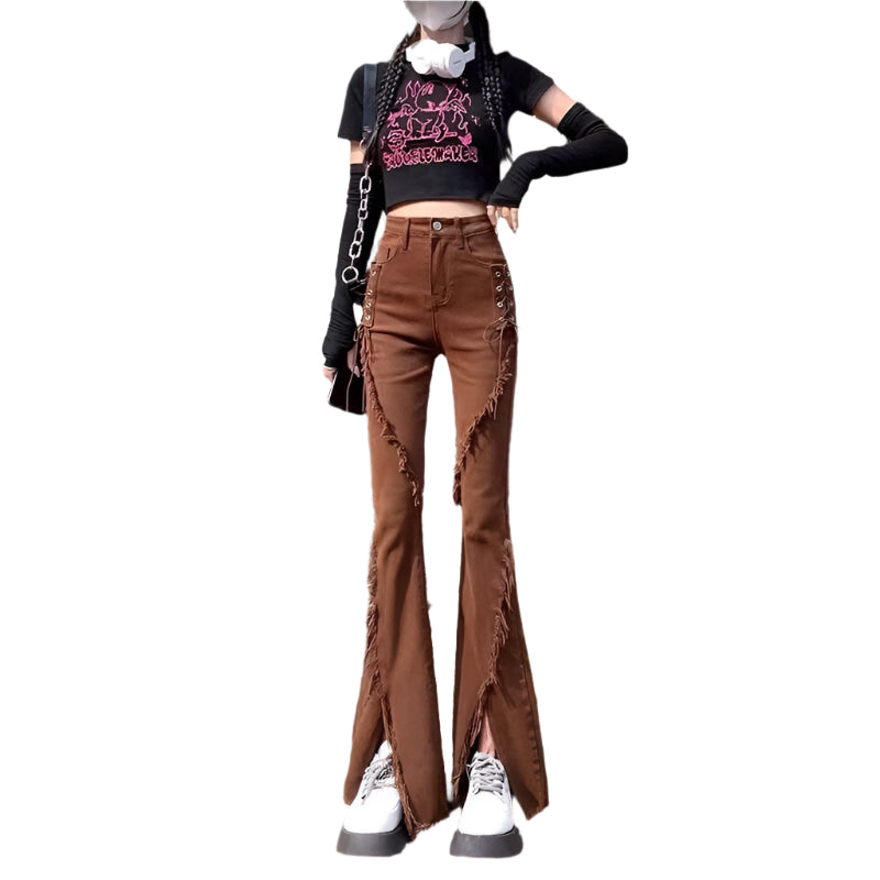 Person wearing a black crop top with pink text, brown flared jeans, and white sneakers standing outdoors.
