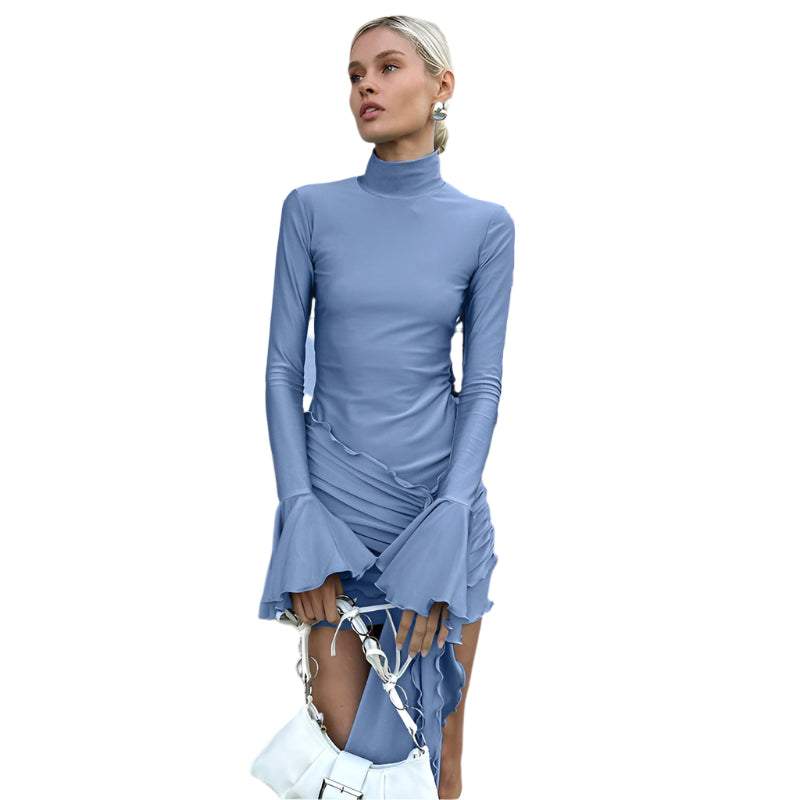 Woman in a blue dress standing outdoors near a building