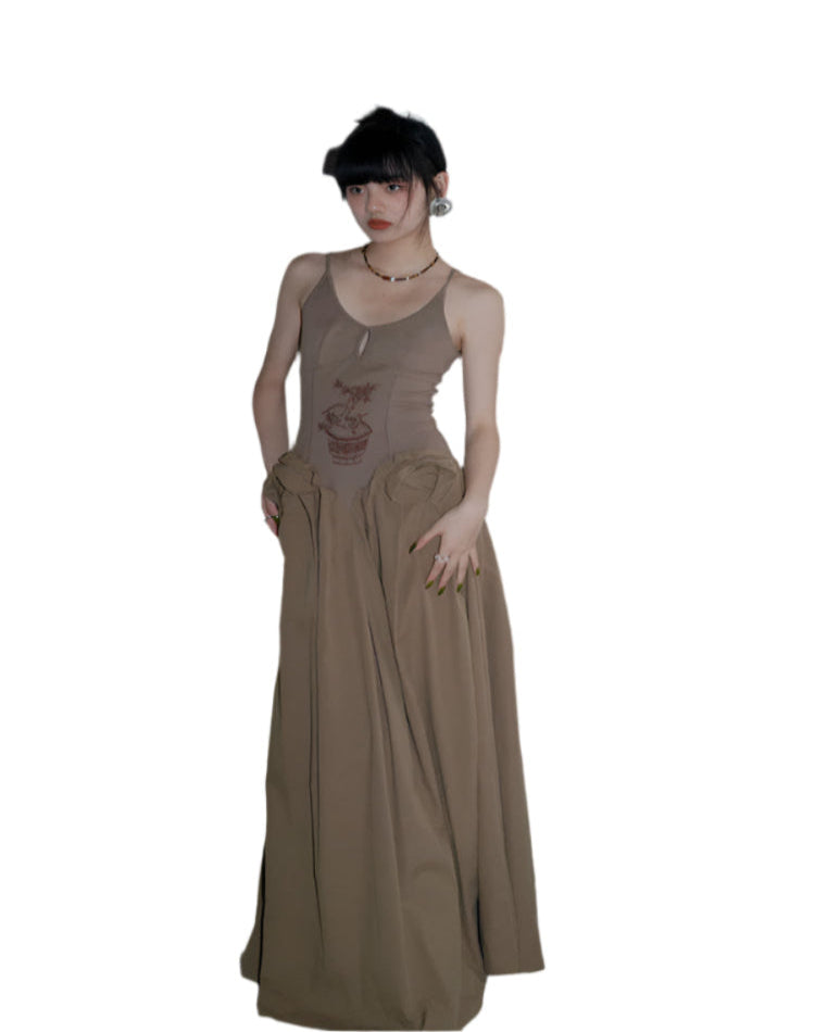 Woman wearing a long beige dress standing in a room with a wooden cabinet and plants.