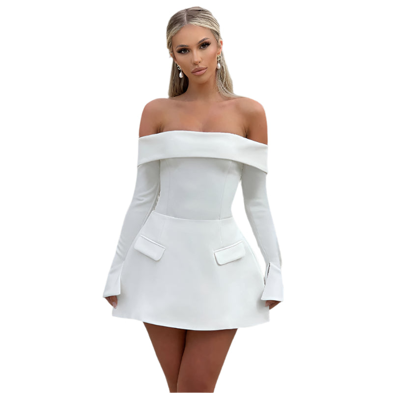 Woman wearing a white off-shoulder dress in front of a building.