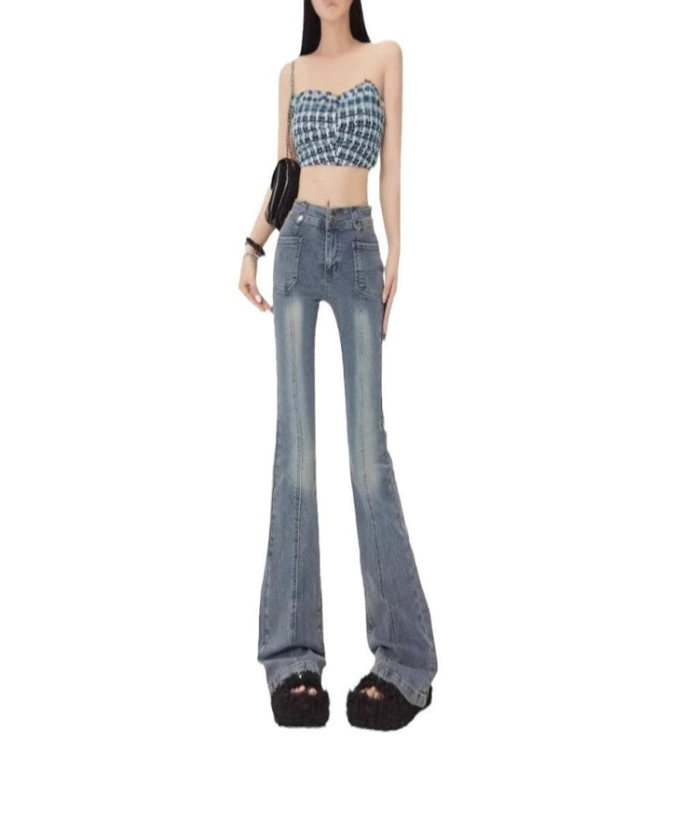 Woman wearing a checkered crop top and blue flared jeans on a white background