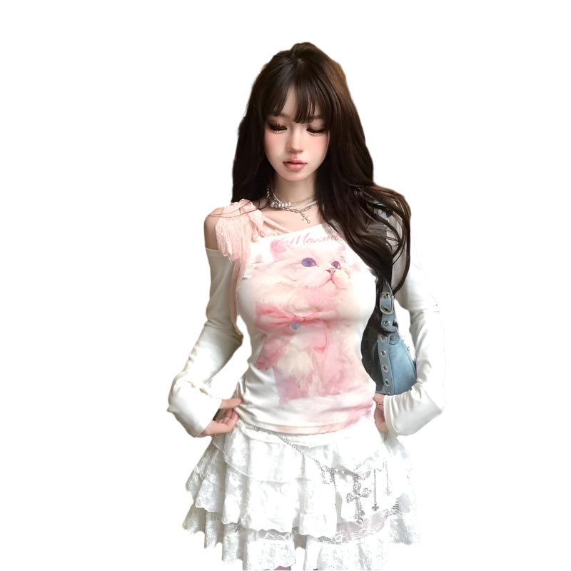 Woman in a cafe setting wearing a pink top with cat design and white skirt.