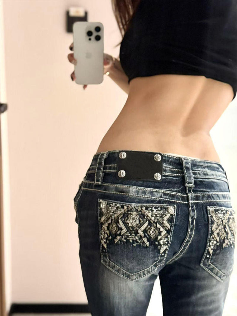 Person wearing embellished jeans taking a mirror selfie.